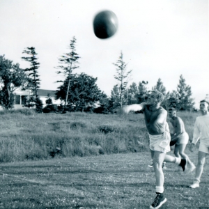 UNTD Sports Tabloid, HMCS Cornwallis, July 1964, Ray Mofford throwing medicine ball; David Cooper behind in white, Peter Kincaid no top, all Haida Division.